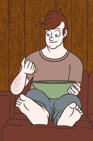 Cillian sits on his couch with a green salad bowl in his lap. We see him from the front and get a generous view of his feet on the ottoman.