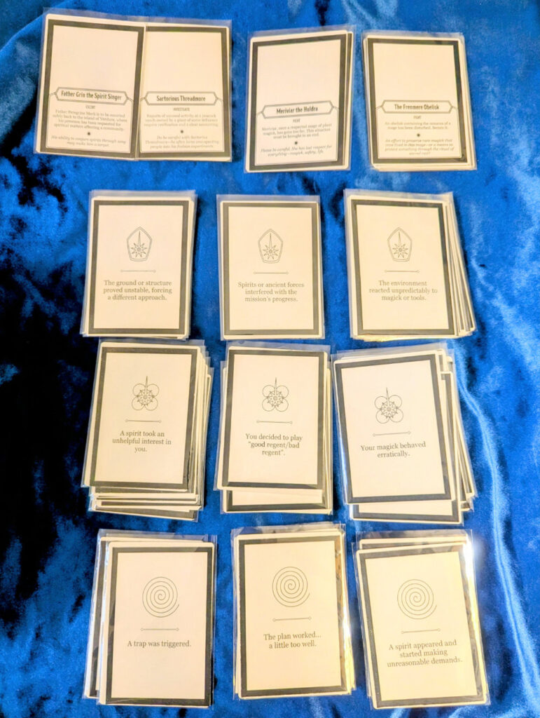 A series of homemade poker-sized cards in penny sleeves.